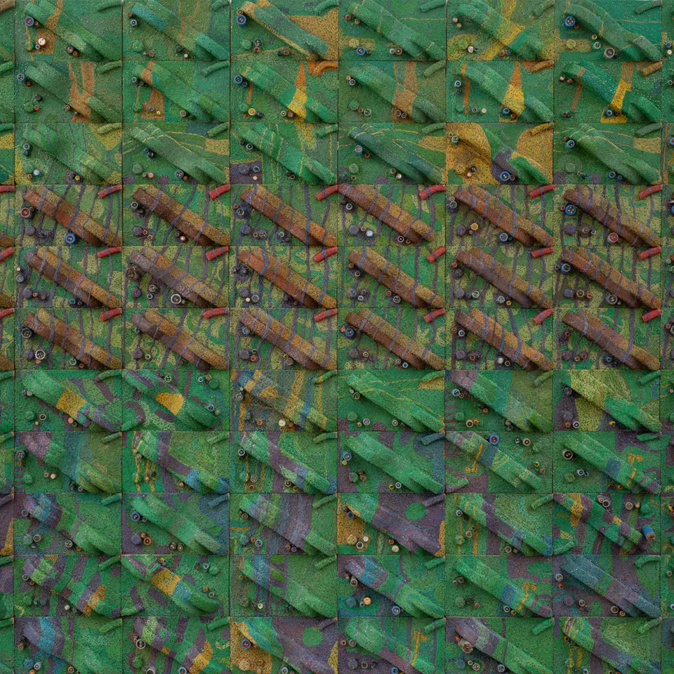 A colour photograph of Elias Sime's three-dimensional wall piece that looks like an aerial view of maps, with a layered texture made from wires and other components in shades of greens, yellow, blue, purple, brown and red.