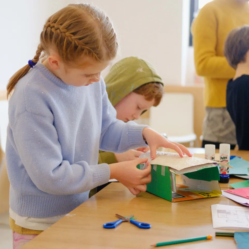 A colour photograph of children making collages in our learning studio.